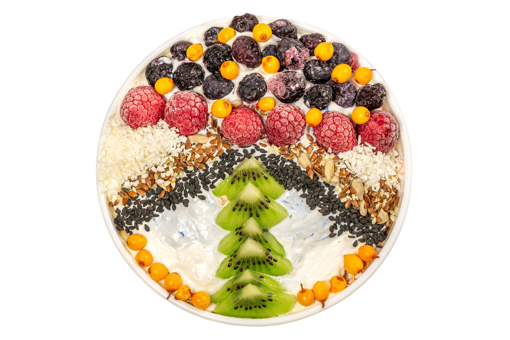 Oat flakes with sesame seeds, flax, sunflower, raspberries, blueberries, sea buckthorn and yogurt, top view