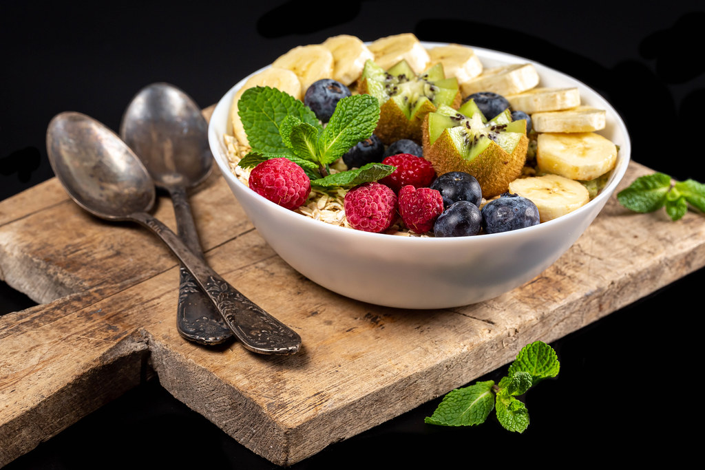 Oatmeal with raspberries and blueberries, banana and kiwi slices