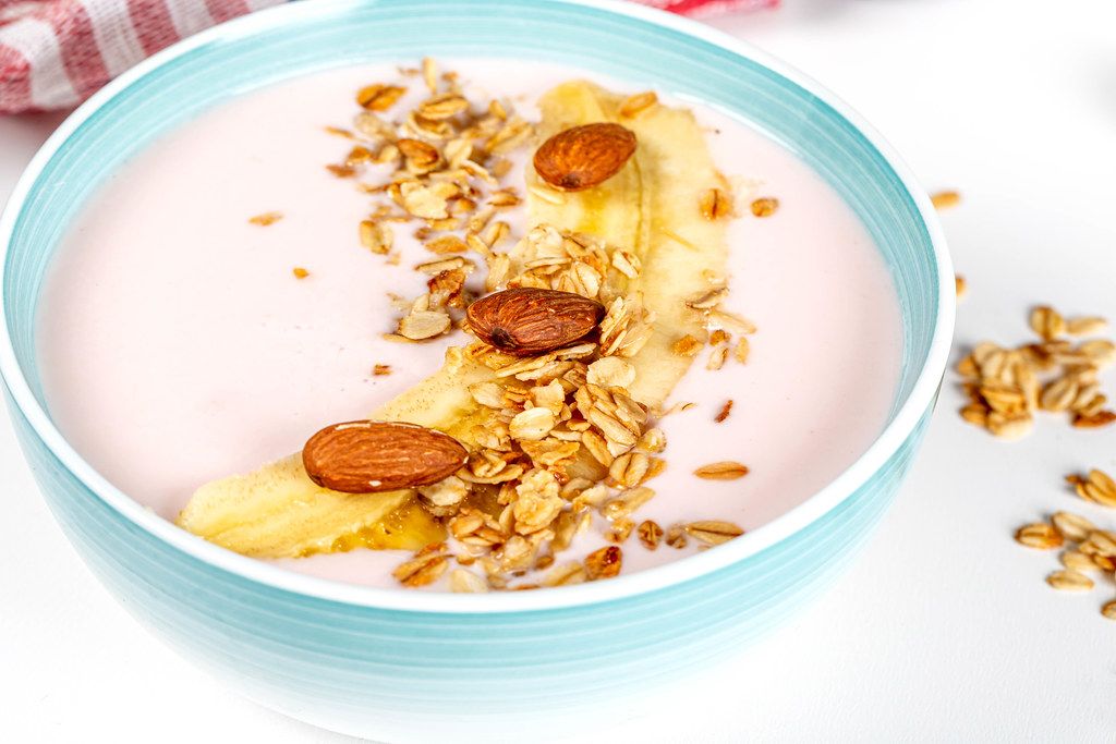 Oatmeal with yogurt, banana and almonds, close-up