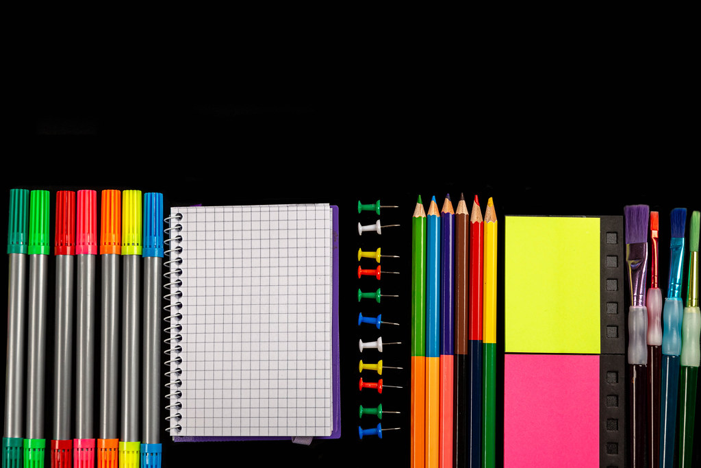Office supplies on black background, top view