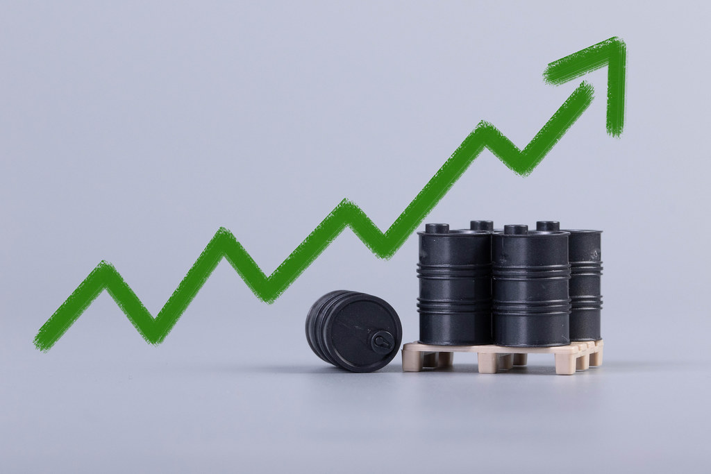 Oil barrels with green up chart on grey background