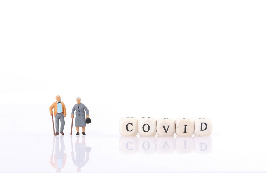 Old couple with Covid text on white background