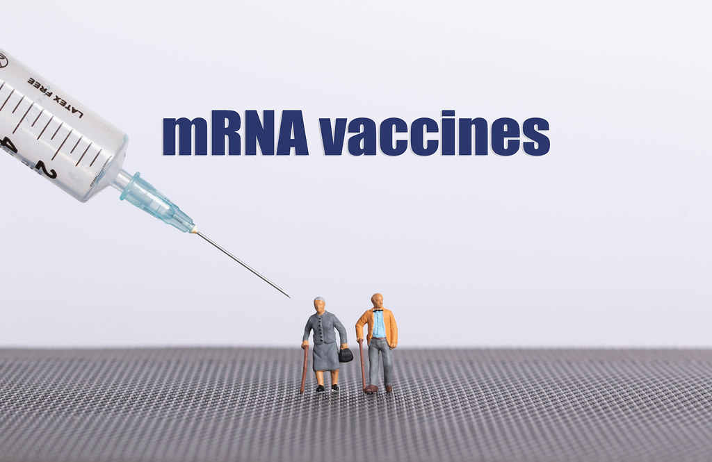 Older couple with syringe and mRNA vaccines text