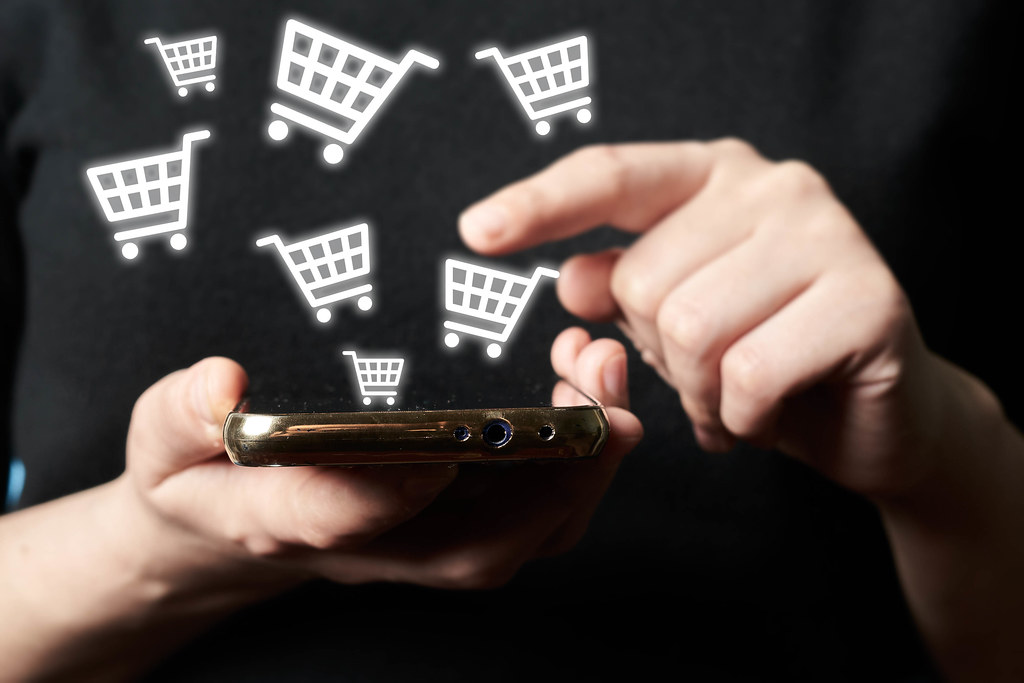 Online shopping and payment - man using smartphone with shopping cart icons