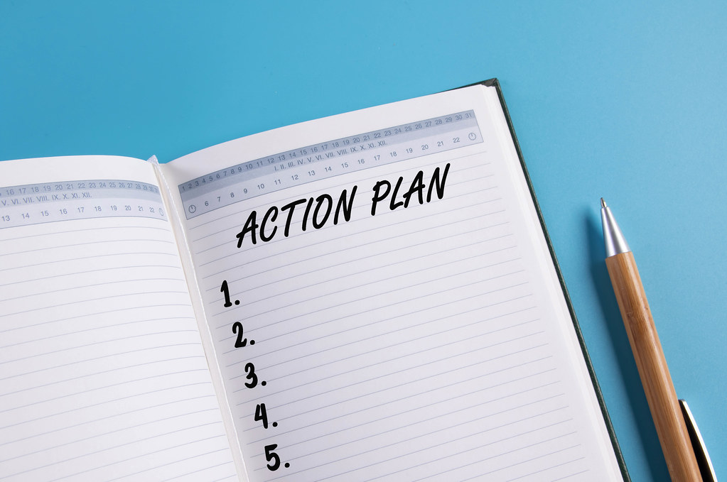 Open notebook with Action plan list on blue background