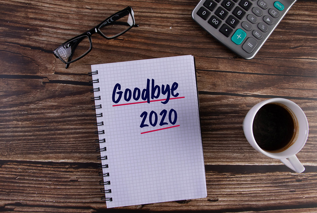 Open notebook with Goodbye 2020 text on wooden table