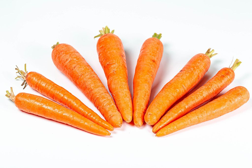 Orange young carrots on white