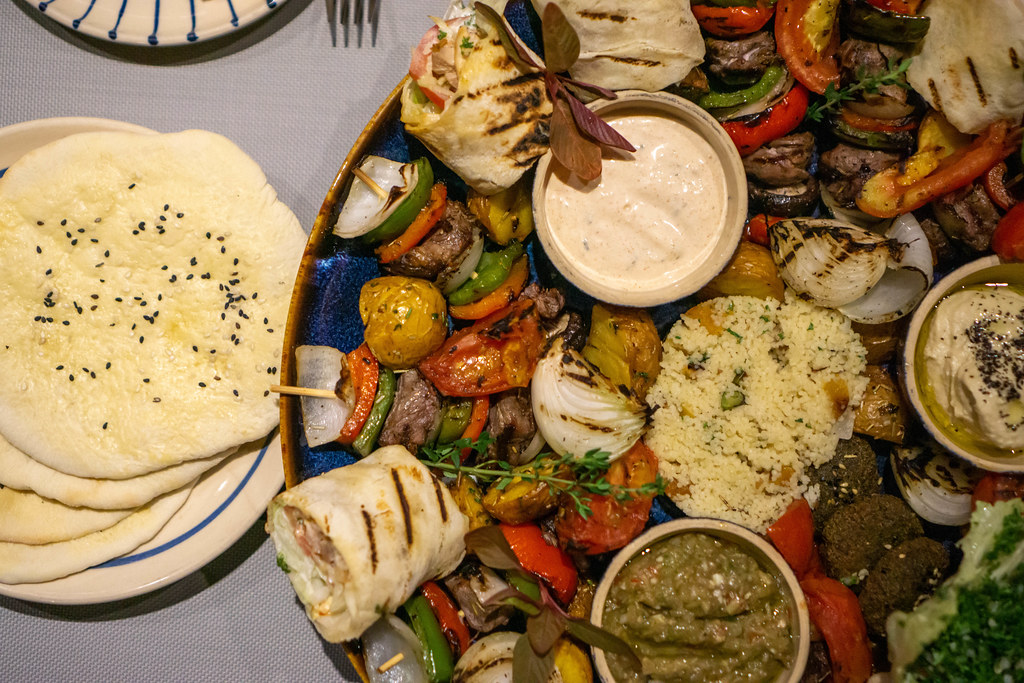 Orientalische Sultan Platte mit vielen verschiedenen Gerichten wie Hähnchen Shawama, Hummus, Falafel, Pita Brot, Gegrilltes Gemüse, Rindfleisch Spieße und Soßen von oben fotografiert
