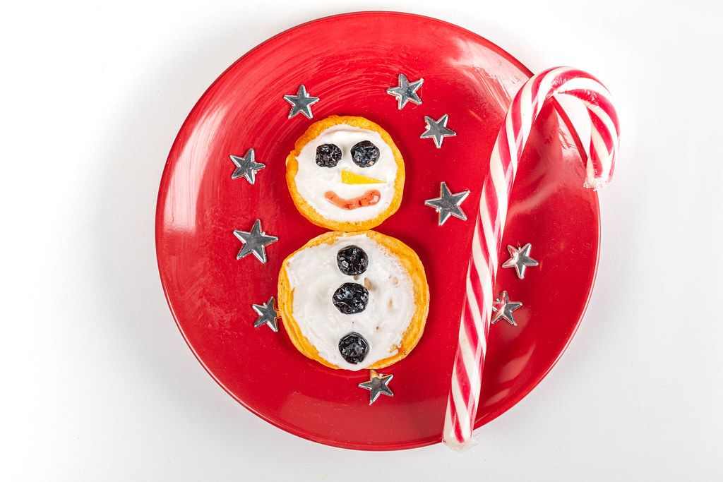 Pancakes snowman on a red plate with stars, top view