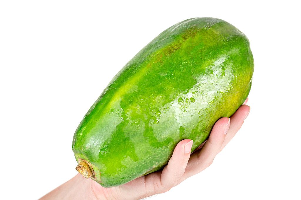 Papaya in man hand on a white background