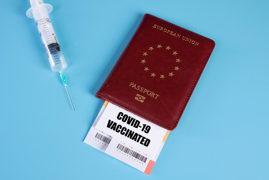 Passport and Covid-19 vaccination certificate with syringe