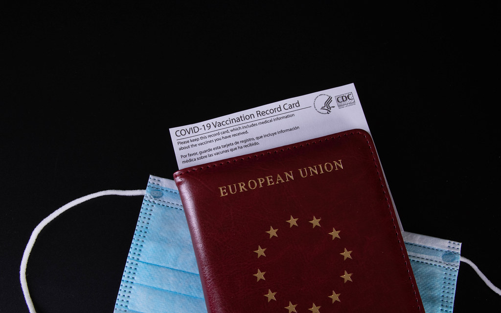 Passport, medical face mask and Vaccination record card on black background
