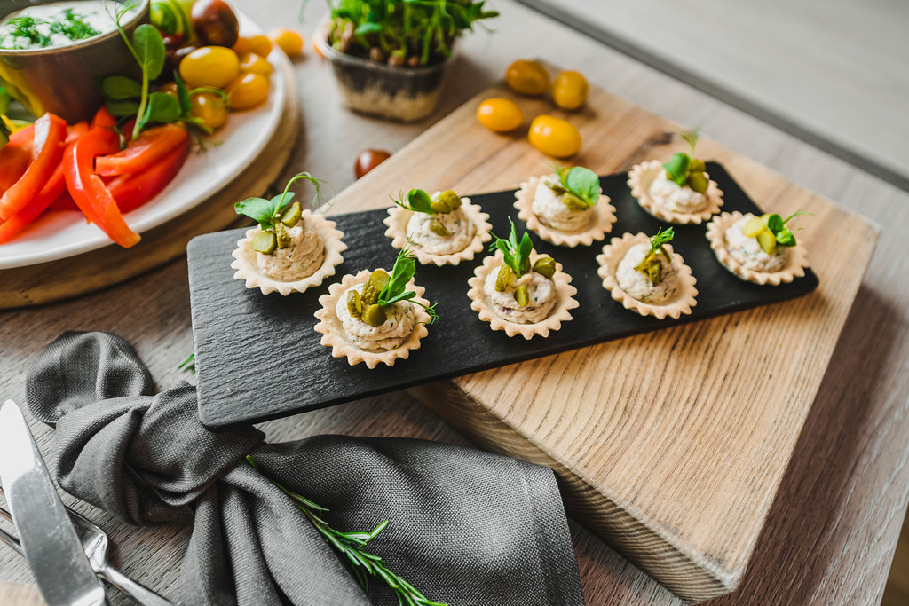 Pastry Canapes With Cream And Greens On Black Plate.jpg