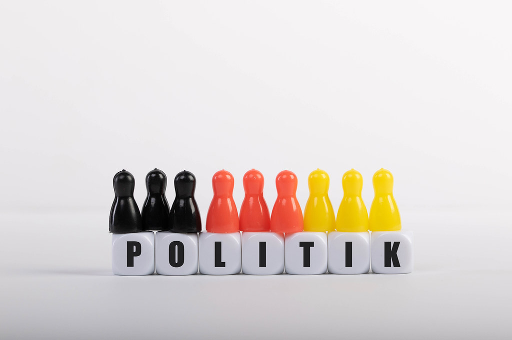Pawn figurines with cubes and Politik text on white background