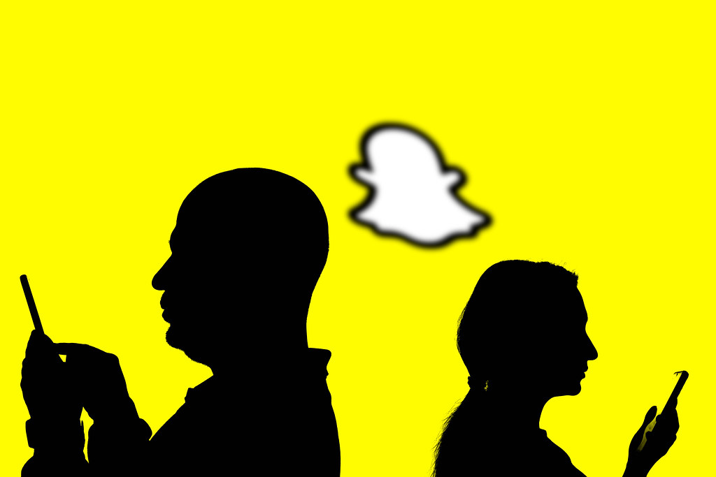 People silhouettes over popular Snapchat logo