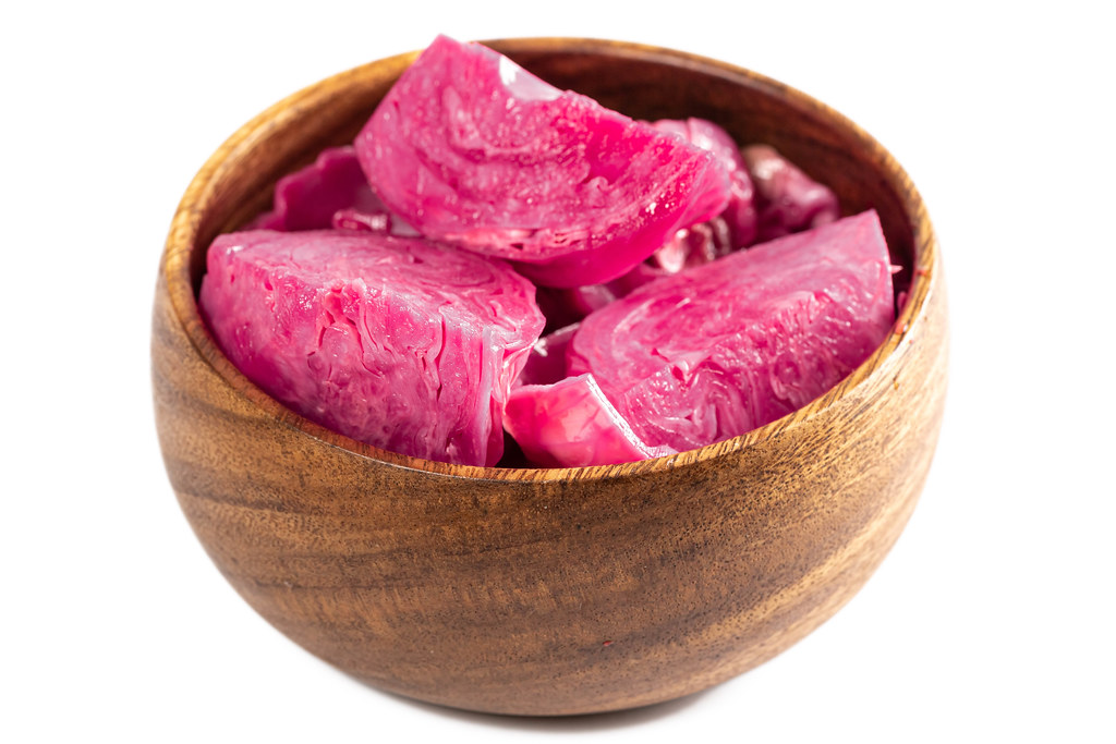 Pickled cabbage with beets in wooden bowl
