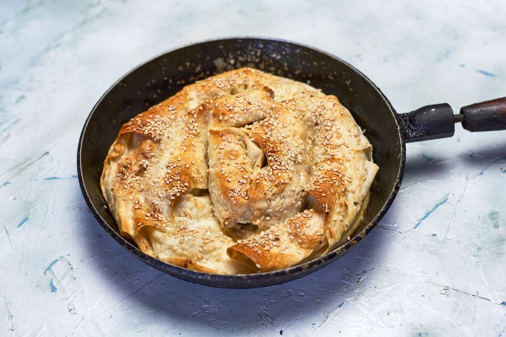 Pie in skillet pot with meat and puff pastry set