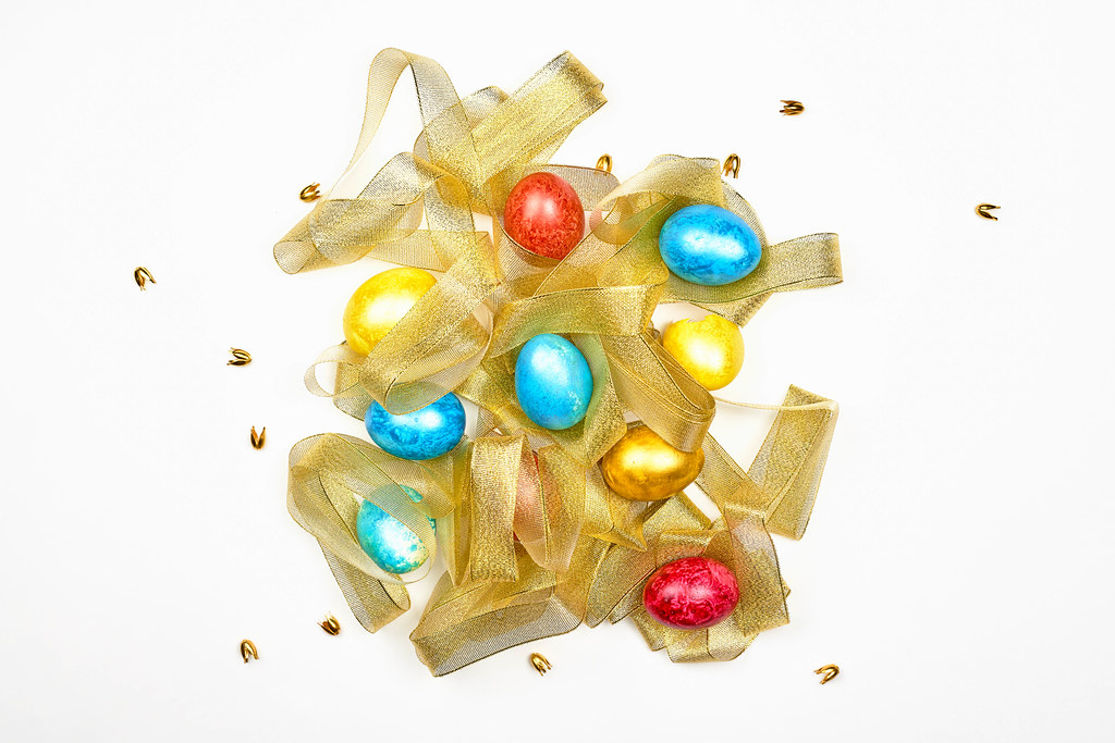 Pile of colorful Easter eggs with golden ribbon
