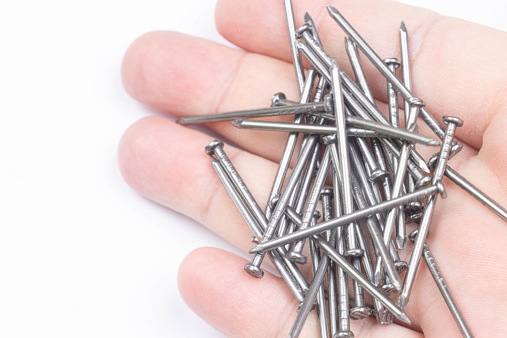 Pile of Nails in the hand above white background