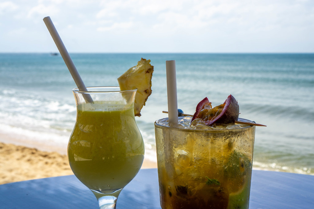 Pina Colada mit frischer Ananas und Mojito mit Passionsfrucht, Eiswürfeln und Minze in Cocktailgläsern in einer Strandbar mit Meerblick in Phu Quoc, Vietnam