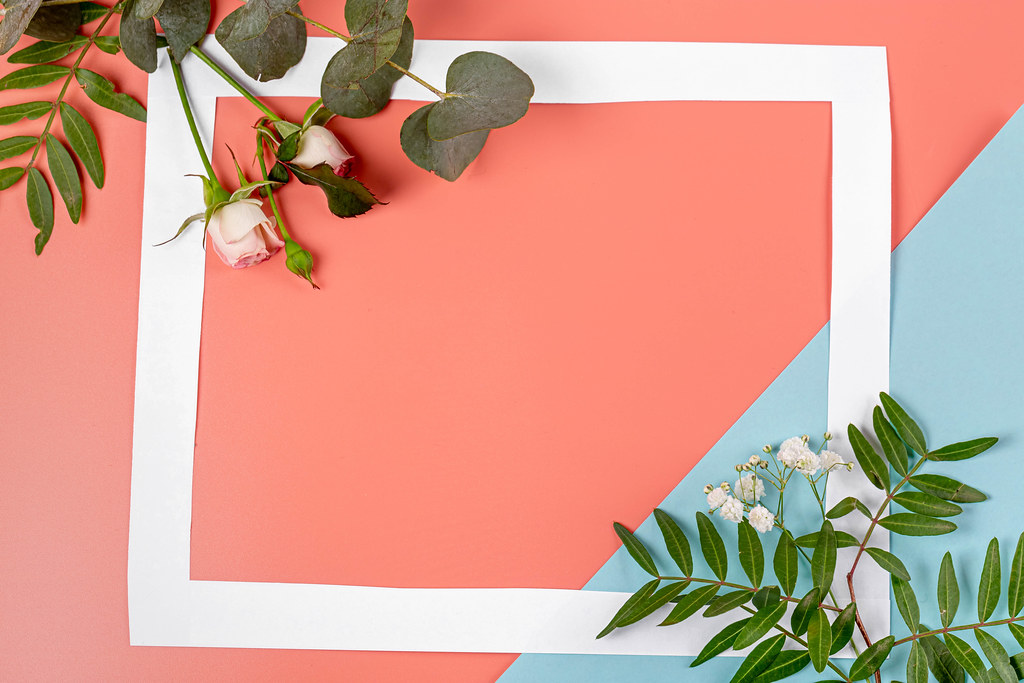 Pink-blue background with leaves and flowers with a free space in the middle