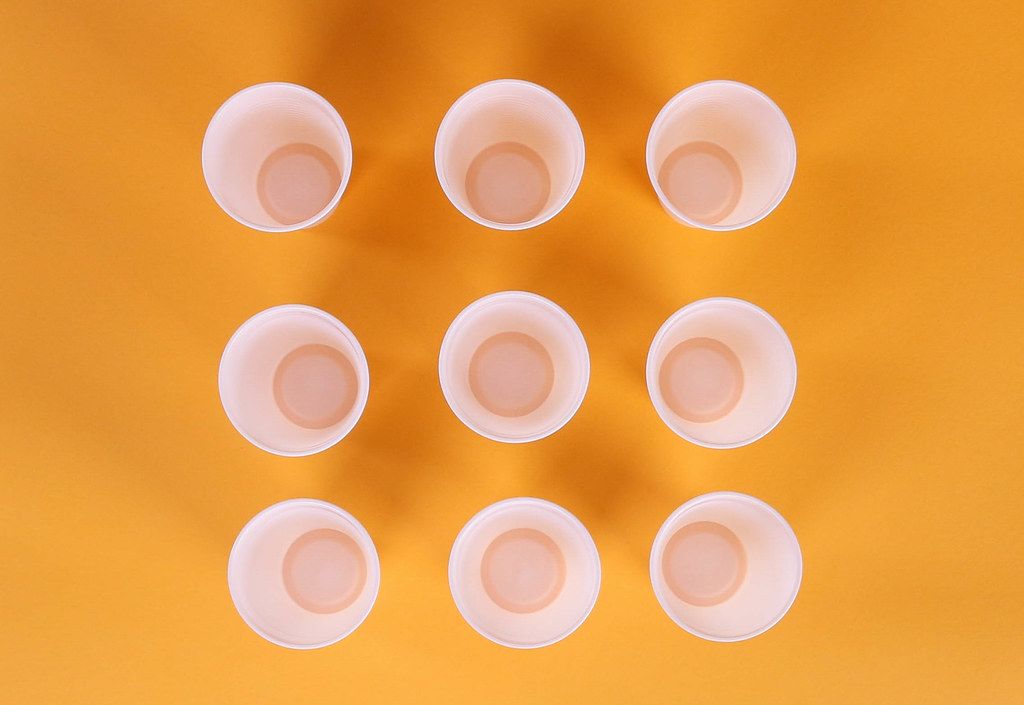 Plastic cups on orange background