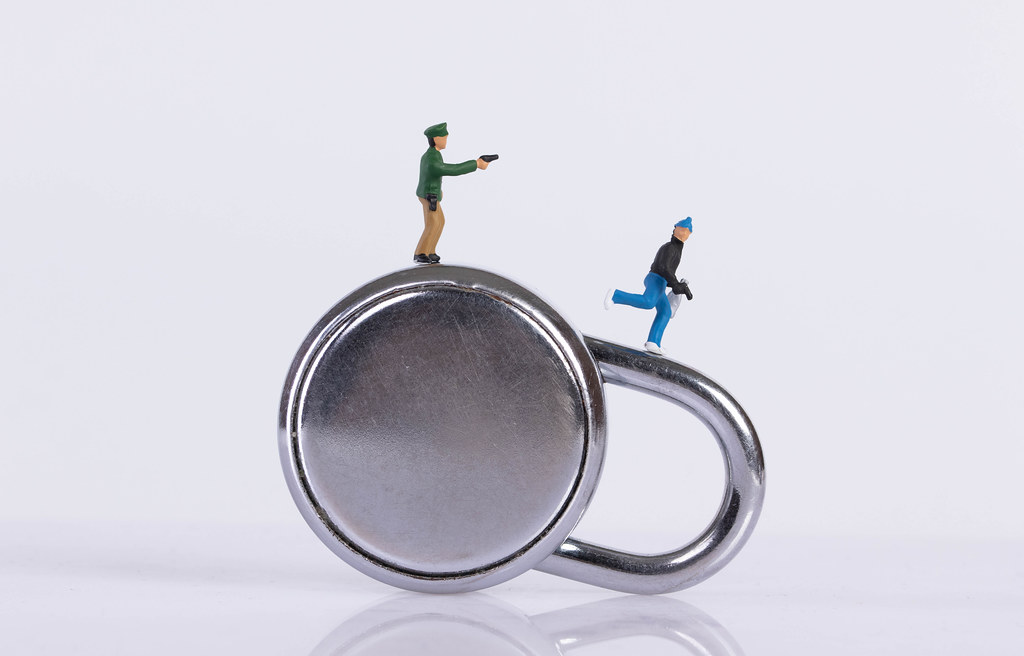 Policeman and robber with padlock on white background