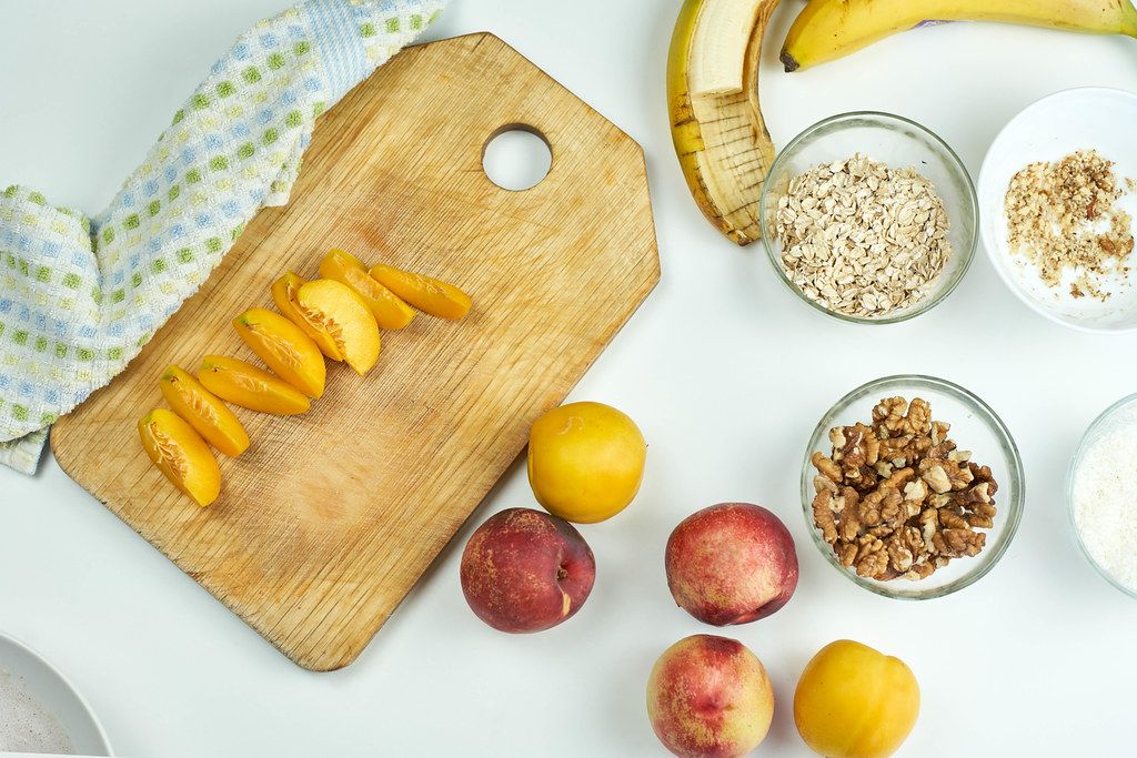 Preparing nutritious snack with oats, peach and banana fruits