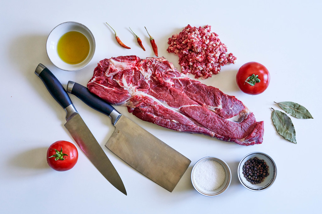 Raw fresh meat beef steak and butcher knife on white background