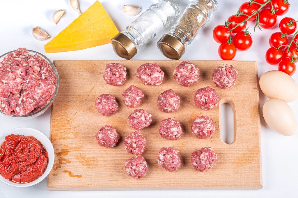 Raw meat balls with sauce ingredients on the table, top view