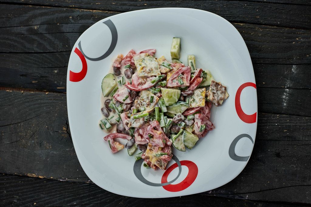 Red kidney bean salad made with sour cream, tomato and cucumber slices