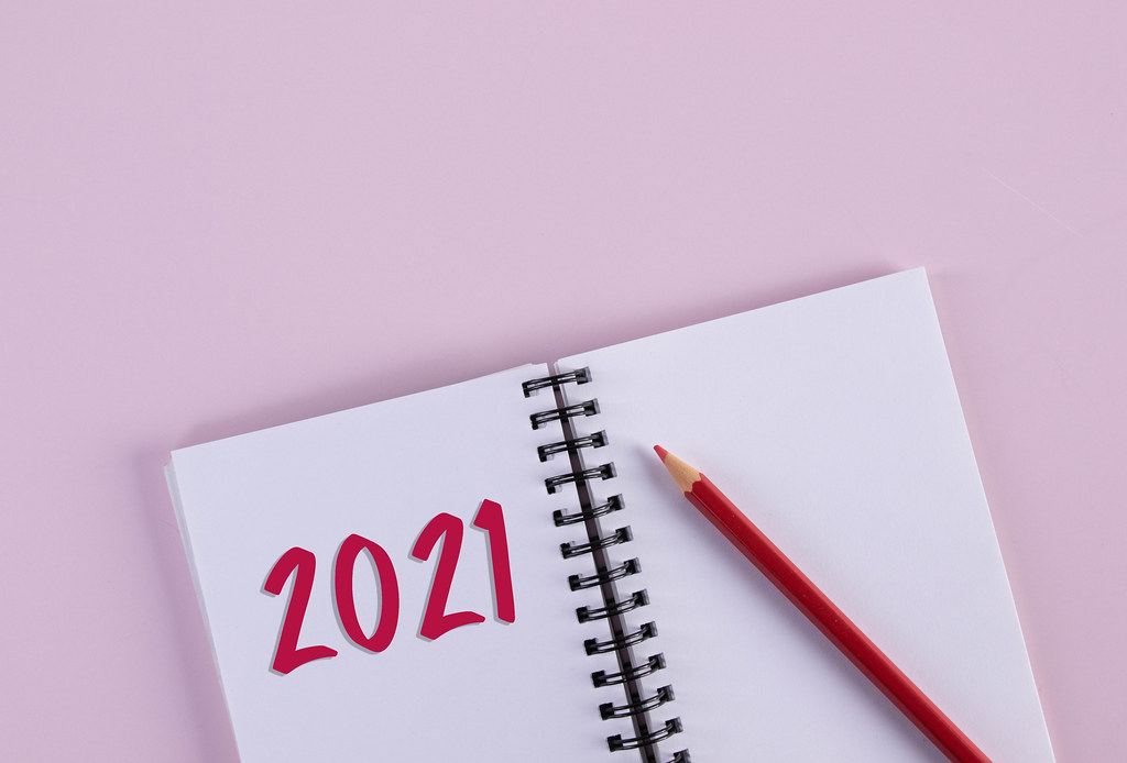 Red pencil and open notebook with 2021 text