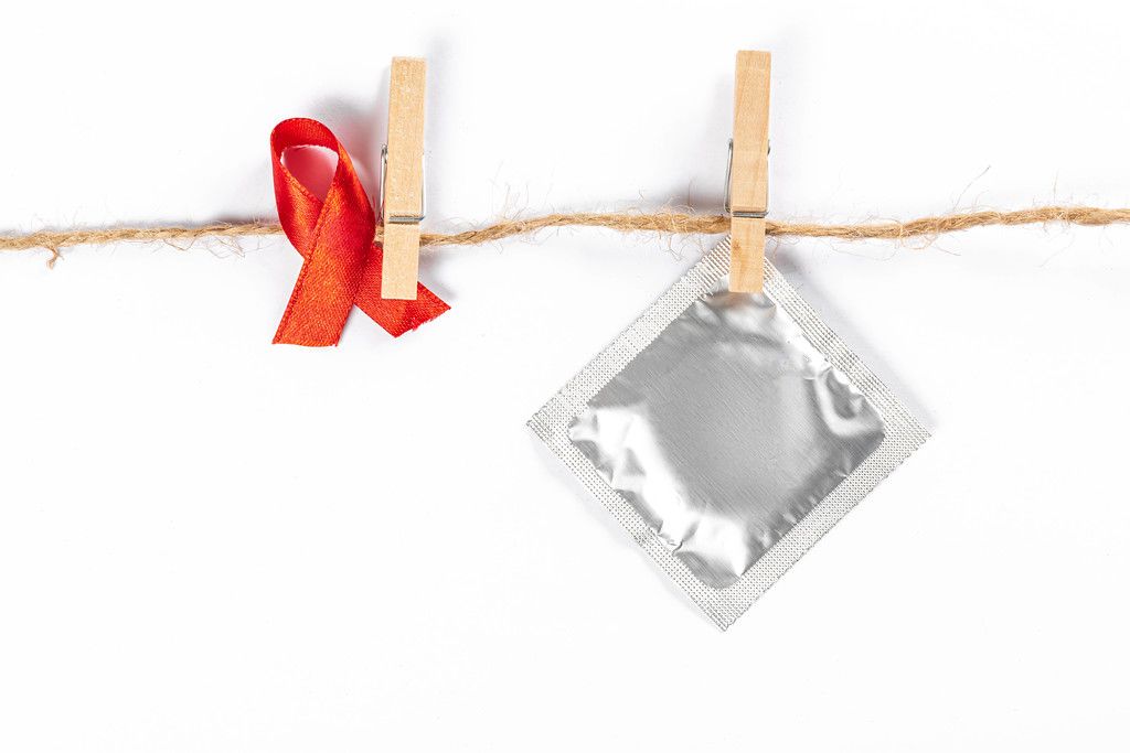 Red ribbon and condom with clothespins hanging on a rope