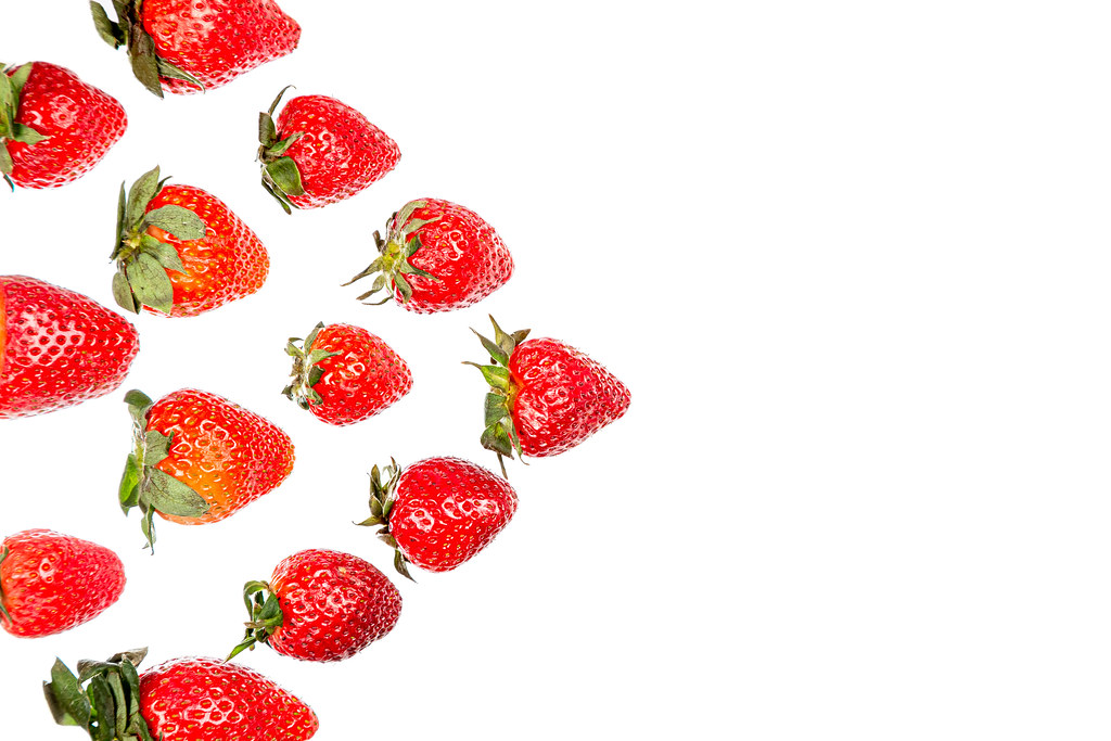 Red strawberries lined with triangle on white with free space