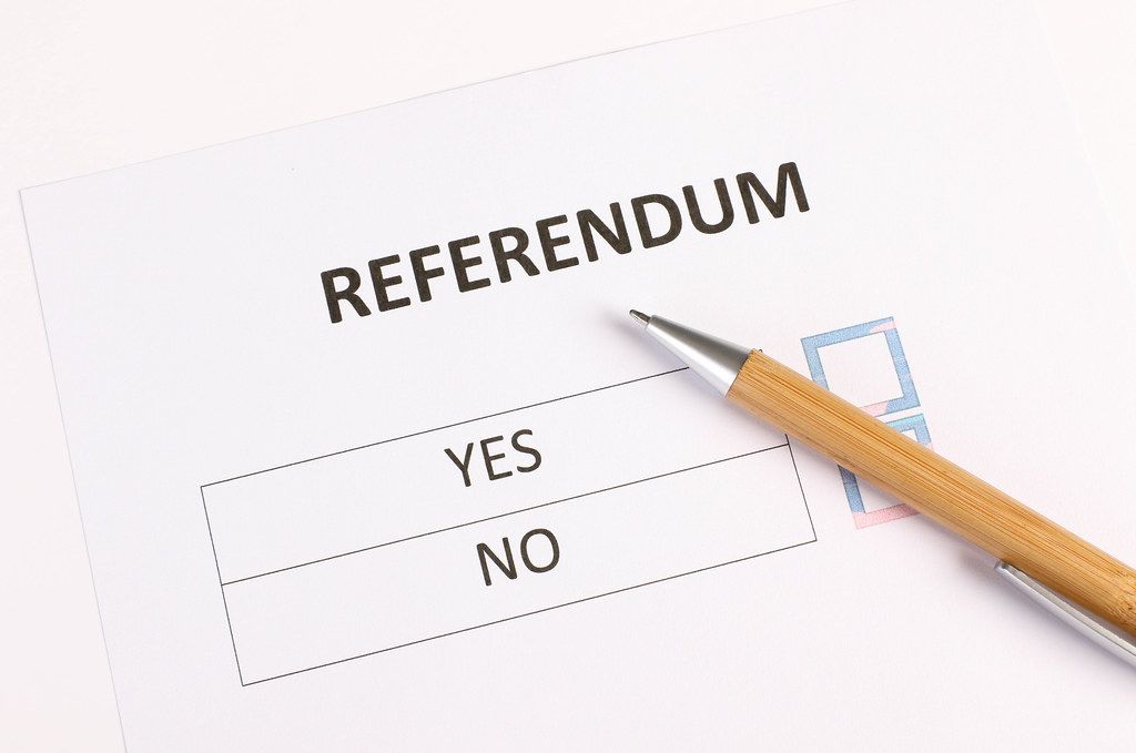 Referendum form with wooden pencil on white table
