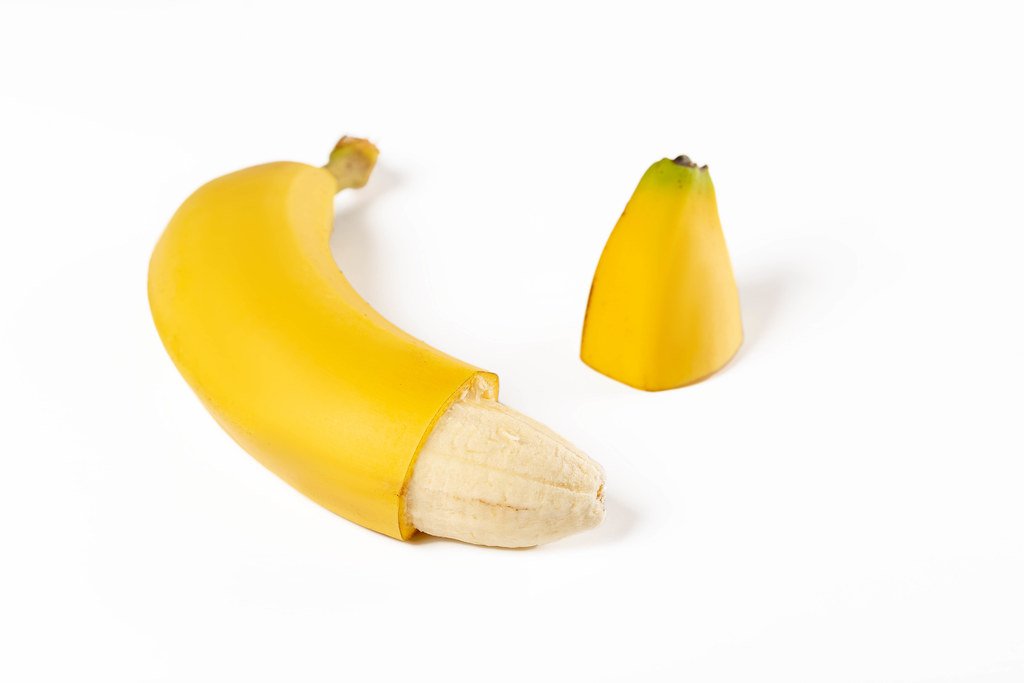 Ripe banana with the cut off part of a peel