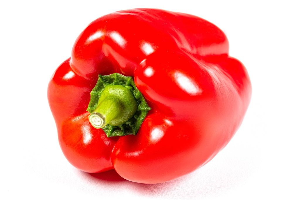 Ripe red bell peppers on white background
