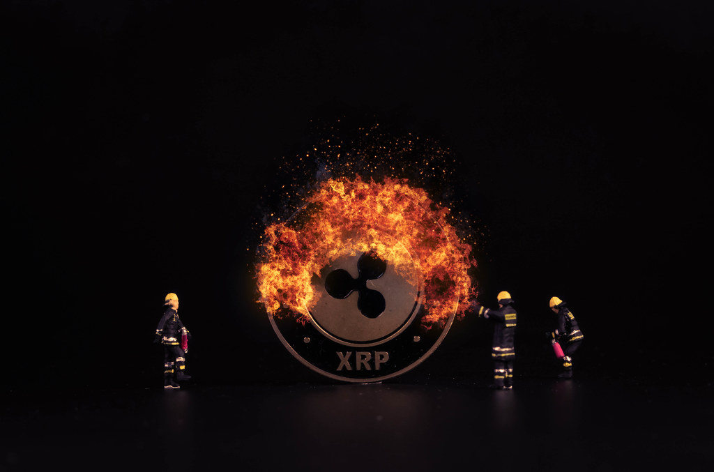 Ripple coin on fire and miniature firefighters