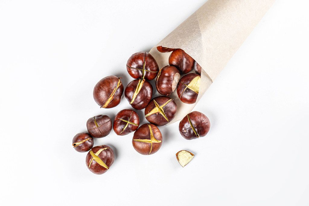 Roasted chestnuts on white background, top view