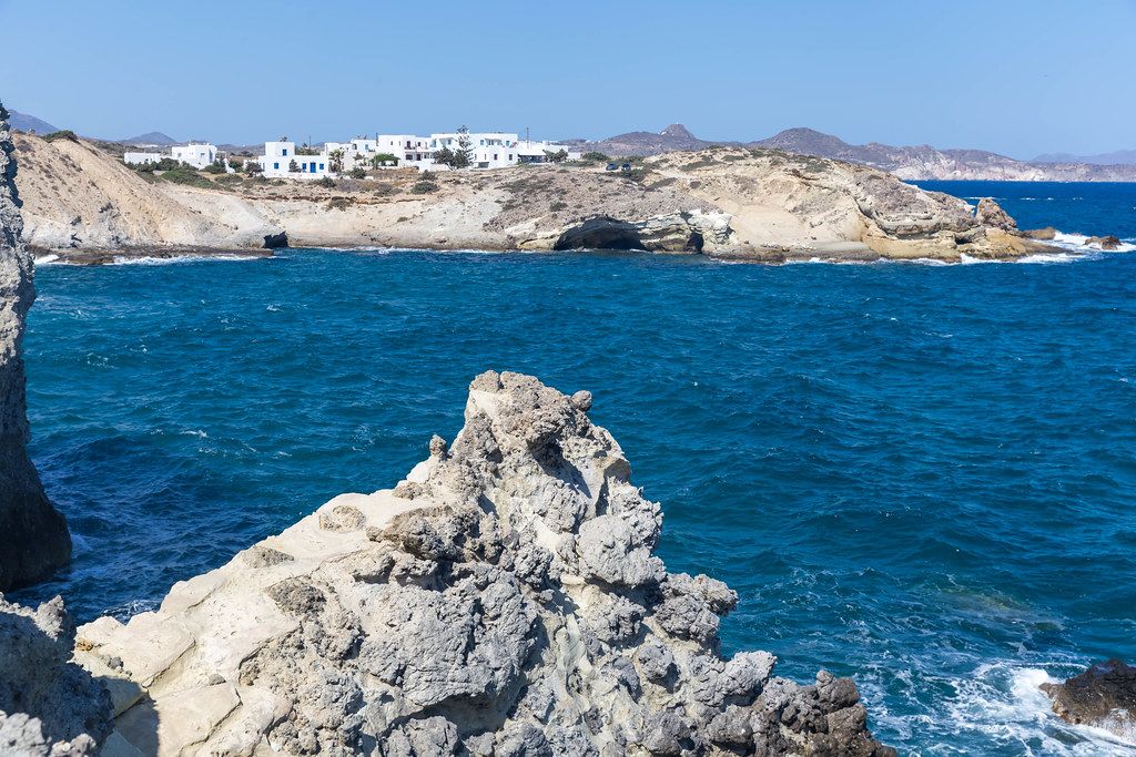 Rocks, cliffs and white-blue houses by the sea in the South Aegean on the north coast of Milos