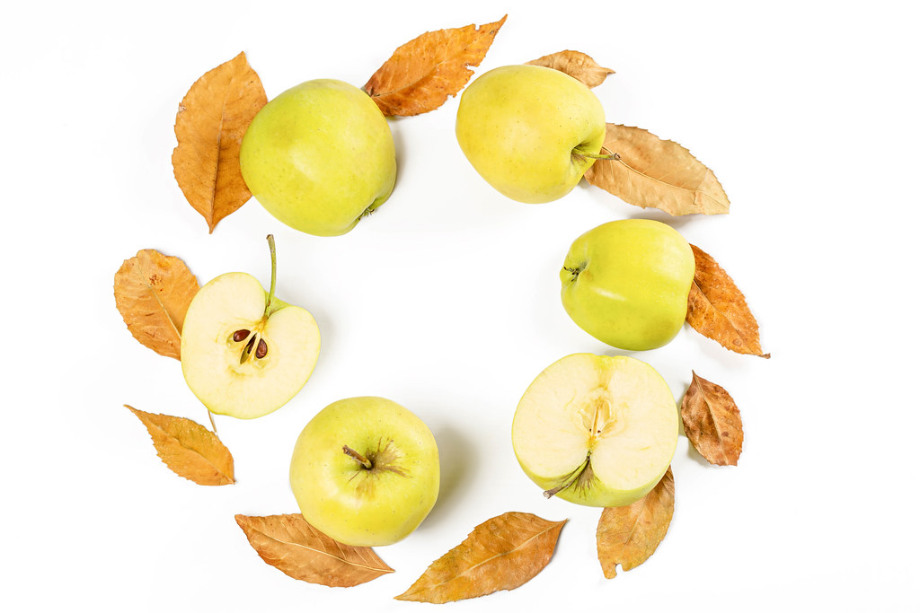Round frame of fresh apples and autumn leaves on white, top view