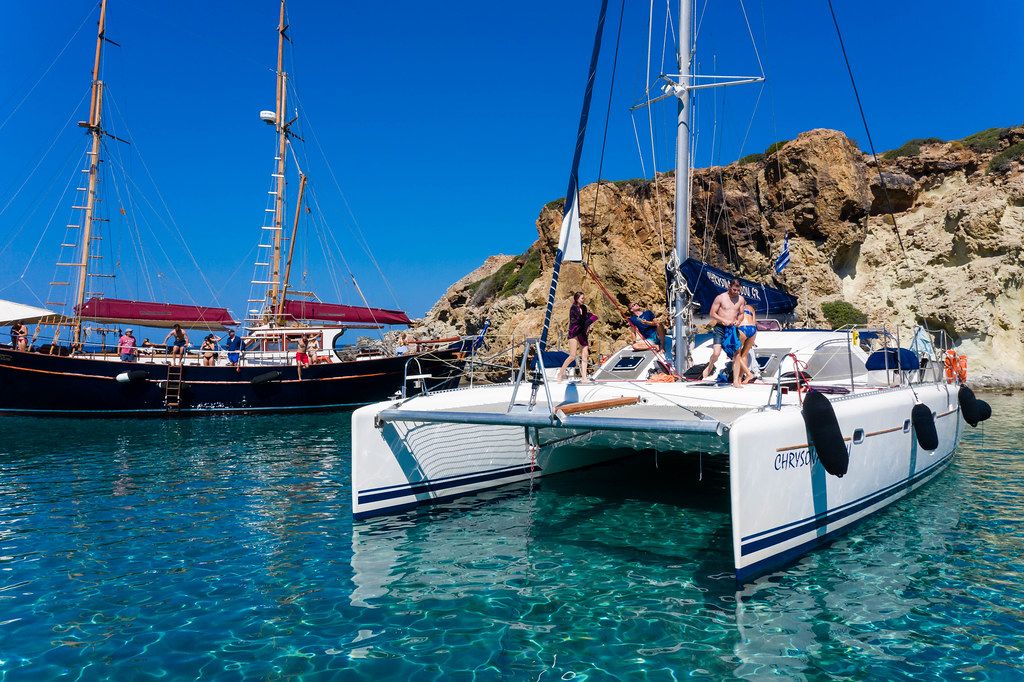 Sailing holidays in Greece: tourists on boats in the crystal clear waters of Milos, south Aegean