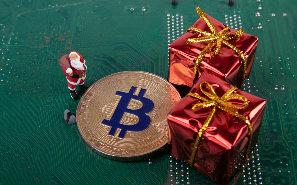 Santa Claus with Bitcoin and gifts on computer motherboard