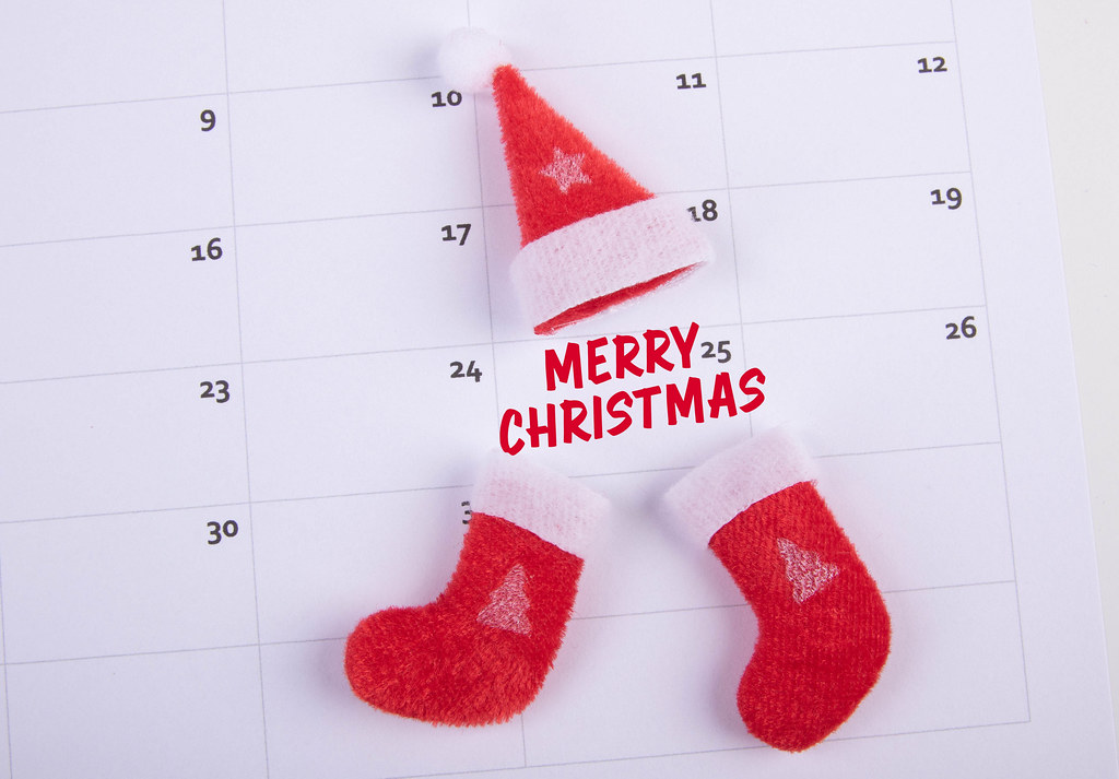 Santas Claus hat and socks with Merry Christmas text on the calendar