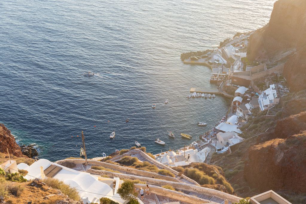 Santorini, the pier, the cliffs and the sea seen from above at sunset