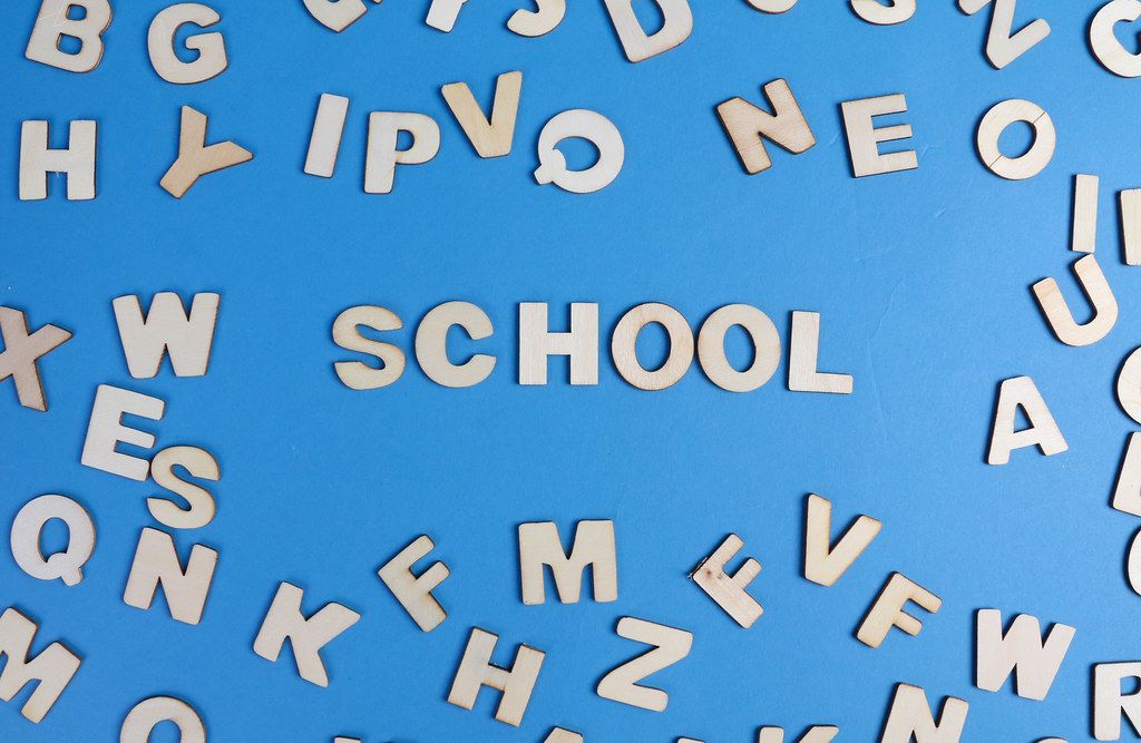 School written with wooden letters on blue background