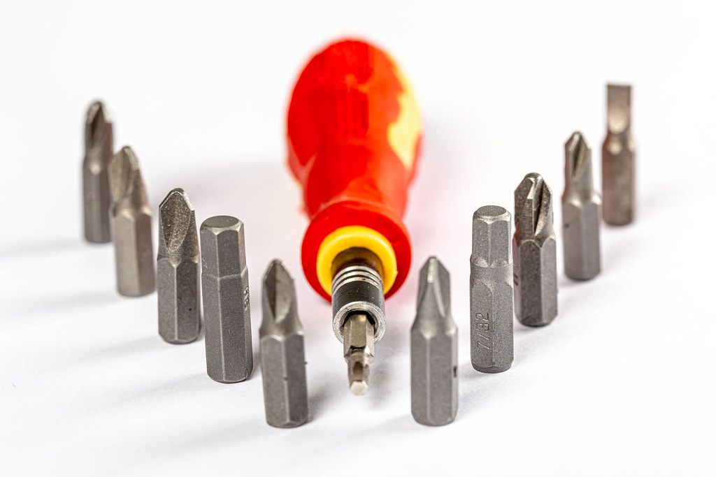 Screwdriver with a set of bits on a white background