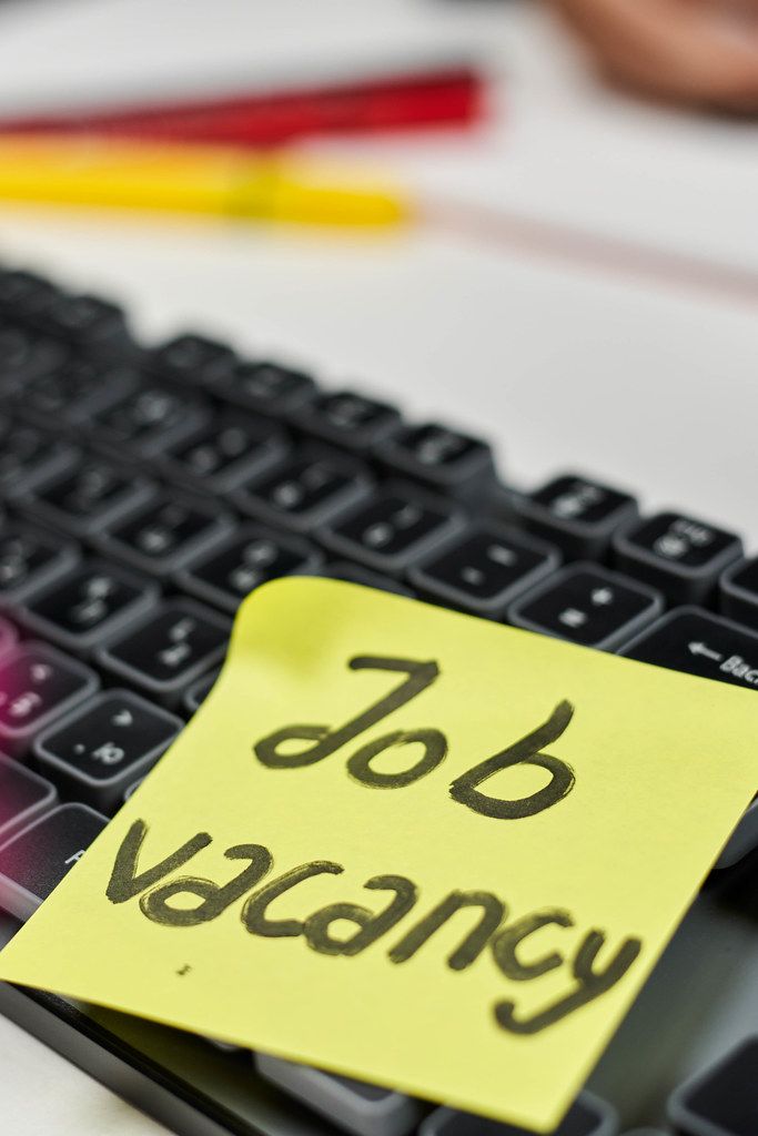 Searching employees. A keyboard and stick note on it with text - Job vacancy
