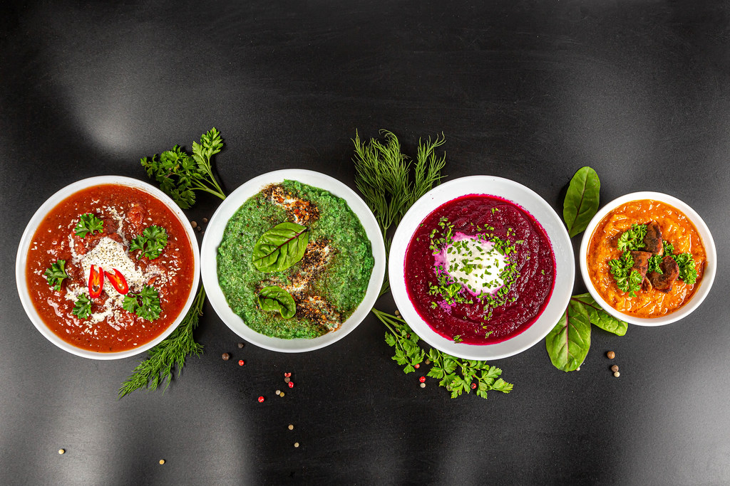 Set of different multi-colored soups on a black background