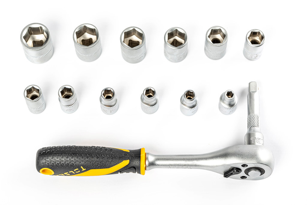 Set of ratchet sockets on white background with ratchet wrench